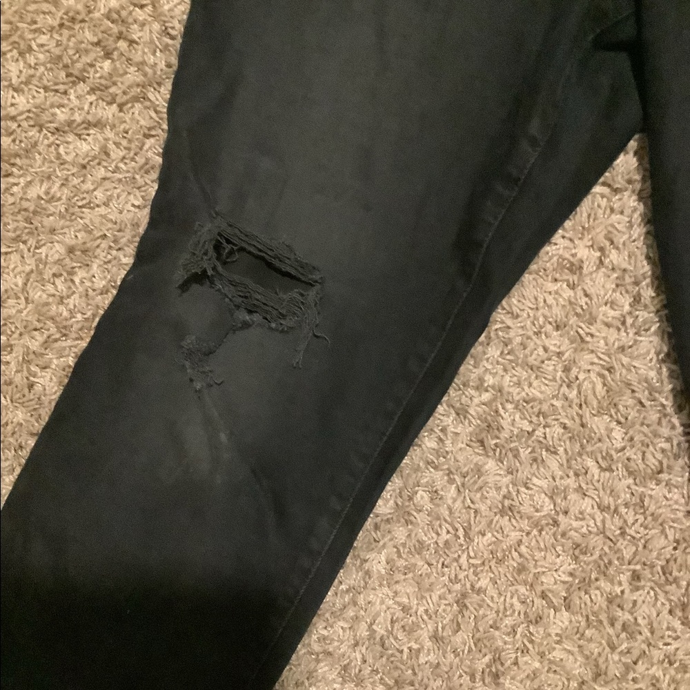 Black jeans with slight holes in the knees